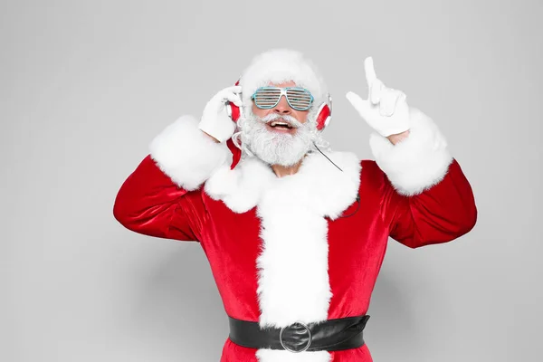 Weihnachtsmann Hört Weihnachtsmusik Auf Farbigem Hintergrund — Stockfoto