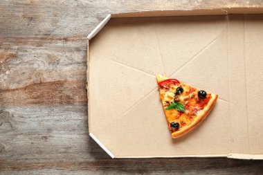 Ahşap masa, üstten görünüm üzerinde karton kutu içinde lezzetli pizza son dilim
