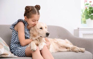 Kanepe evde onun Evcil hayvan ile şirin küçük çocuk