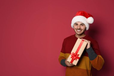 Renk arka plan üzerinde Noel hediye ile genç adam