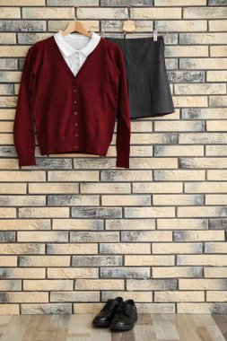 Okul kız tuğla duvara asılı için tek tip