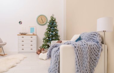 İç dekore edilmiş Noel ağacı olan şık bir oturma odası.