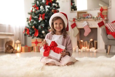 Noel Baba şapkası ile Noel hediye kutusu evde şirin küçük çocuk