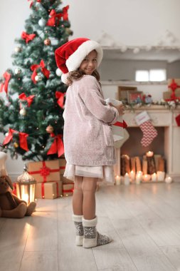 Noel Baba şapkası ile Noel hediye kutusu evde şirin küçük çocuk