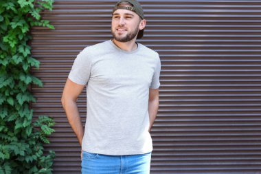 Sokakta duvarının yakınında gri t-shirt giyen genç adam. Kentsel tarzı