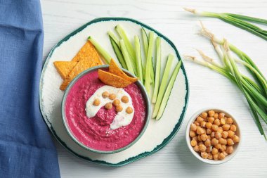 Kase ile düz yatıyordu bileşimi pancar Humus, cips, dilimlenmiş salatalık ve nohut ahşap tablo