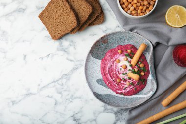 Düz plaka ile bileşimi lezzetli pancar humus yatıyordu ve mermer masada ekmek