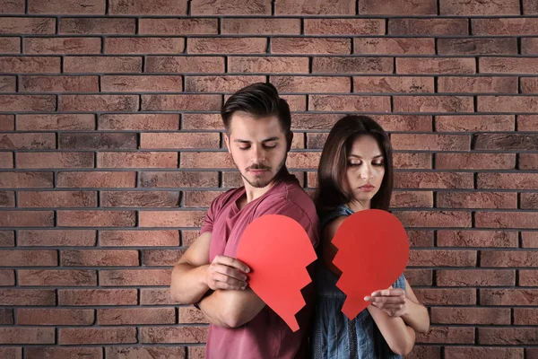 Junges Paar Mit Zerrissenem Papierherz Der Nähe Der Ziegelmauer Beziehungsprobleme — Stockfoto