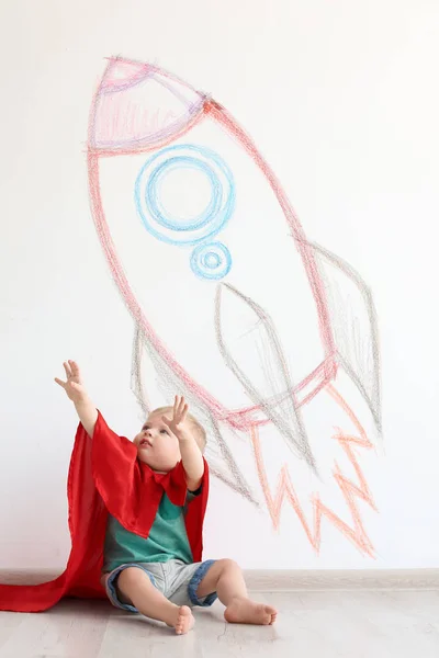 Adorable Niño Pequeño Jugando Astronauta Cerca Pared Con Dibujo Nave —  Fotos de Stock