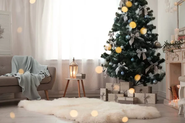 Stylish living room interior with decorated Christmas tree and blurred lights in foreground