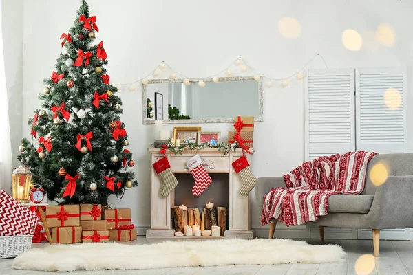 Stylish living room interior with decorated Christmas tree and blurred lights in foreground