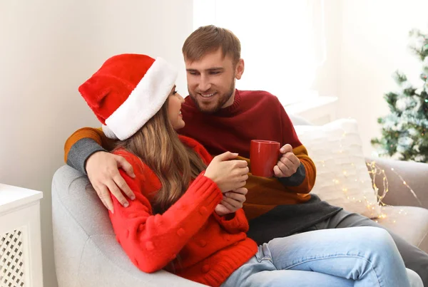 Mutlu genç birkaç bardak sıcak kutluyor Noel evde içecek