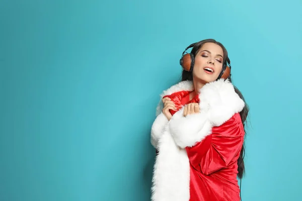 Νεαρή Γυναίκα Στο Santa Κοστούμι Ακούγοντας Μουσική Χριστούγεννα Χρώμα Φόντου — Φωτογραφία Αρχείου