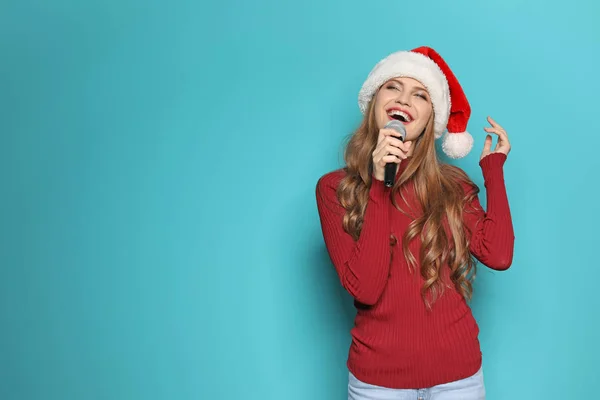 Młoda Kobieta Santa Hat Śpiewa Mikrofonu Kolor Tła Muzyka Świąteczna — Zdjęcie stockowe