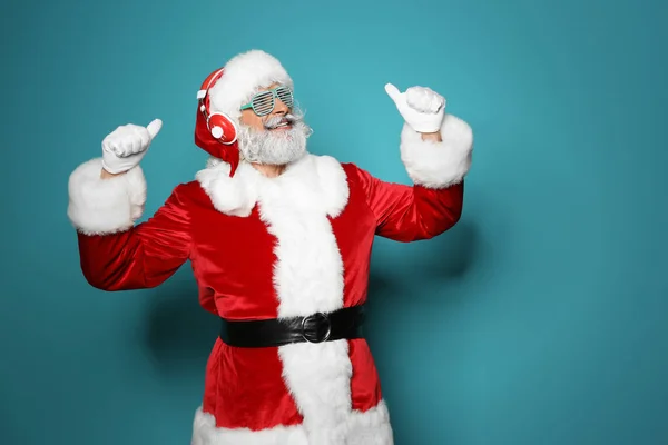 Weihnachtsmann Hört Weihnachtsmusik Auf Farbigem Hintergrund — Stockfoto