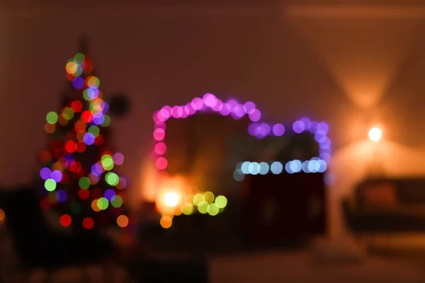 Blurred view of stylish living room interior with Christmas lights at night