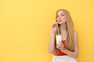 Renk arka plan üzerinde lezzetli milkshake bardak olan kadın