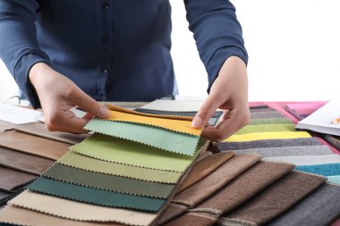 Young woman choosing among upholstery fabric samples, closeup. Interior design clipart