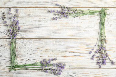 Ahşap arka plan üzerinde Lavanta çiçekleri ile düz yatıyordu kompozisyon