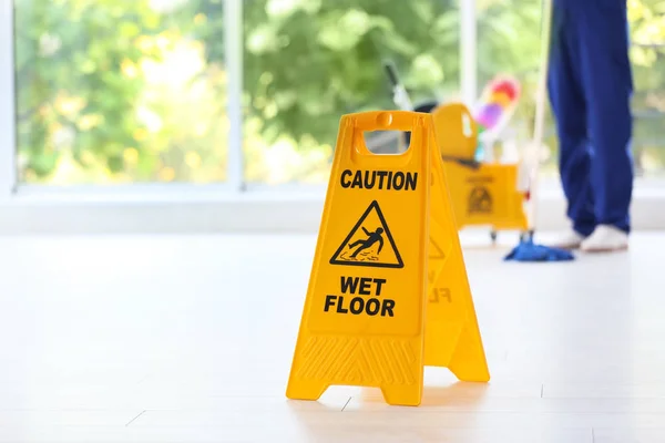 安全标志用词组警告湿地板和模糊的清洁器在背景上 — 图库照片