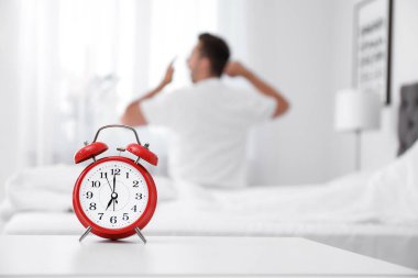 Analog alarm saat ve arka plan üzerinde bulanık adam. Günün saati