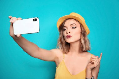 Güzel genç bir kadın, arka planda selfie çekiyor.