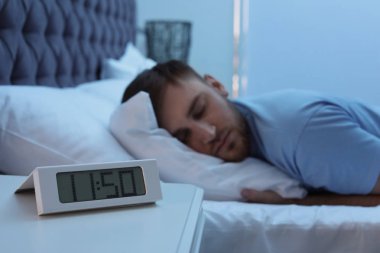 Tablo ve genç adam yatakta gece uyku çalar saat