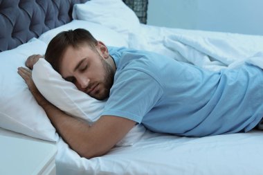 Genç yakışıklı adam yatakta gece uyku