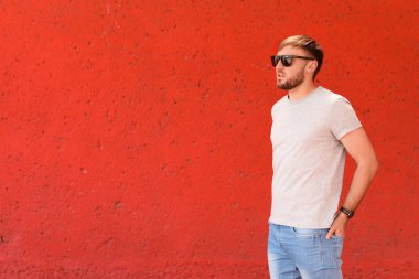 Sokakta renk duvarının yakınında gri t-shirt giyen genç adam