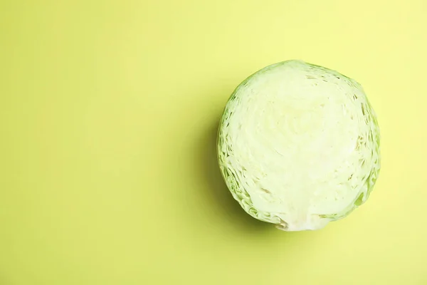 Cut ripe cabbage on color background, top view