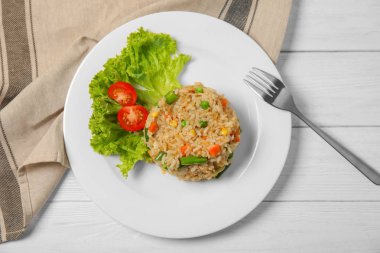 Plaka ile lezzetli haşlanmış pirinç ve sebze masada, üstten görünüm