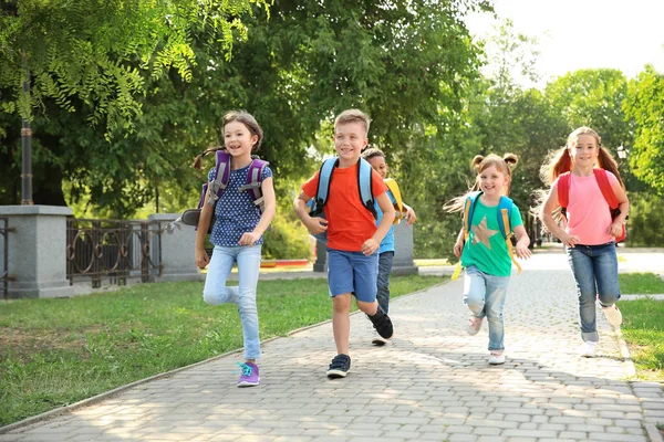 かわいい子供たちとバックパックは アウトドアでのランニングします 小学校 — ストック写真