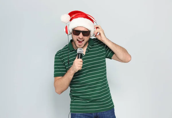 Νεαρός Άνδρας Στο Santa Καπέλο Τραγούδι Στο Μικρόφωνο Στο Χρώμα — Φωτογραφία Αρχείου
