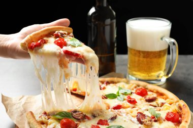 Lezzetli sıcak pizza dilim masa üzerinde closeup tutan kadın