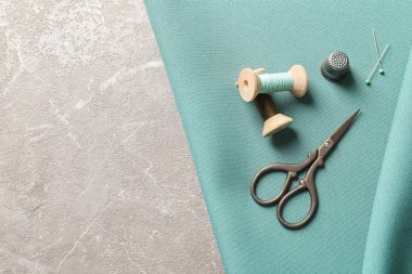 Gri arka plan üzerinde üstten görünüm aksesuarları ve kumaş dikiş seti