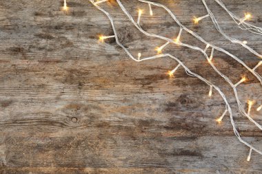 Ahşap arka plan, üstten görünüm parlak Noel ışıkları