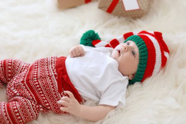 Tüylü halı üzerinde Noel şapkalı güzel bebek