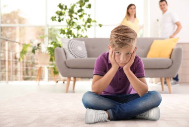 Çocuk anne arka plan üzerinde mücadele ederken katta oturan üzgün. Aile ilişkileri