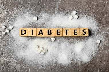 Word şeker hastalığı ve şeker gri arka plan üzerinde düz yatıyordu kompozisyonu