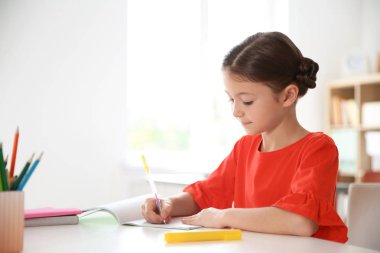Sevimli küçük çocuk sınıfta masasında atama yapıyor. İlköğretim Okulu