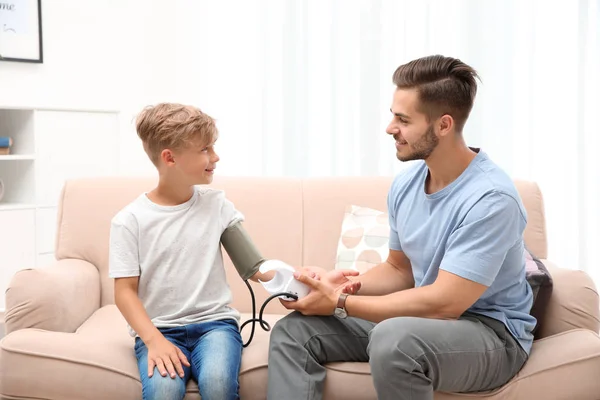 Jonge Man Controle Jongetje Pulse Binnenshuis — Stockfoto