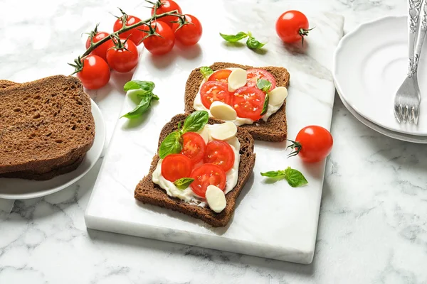 Toast bread with cherry tomatoes and mozzarella cheese on table