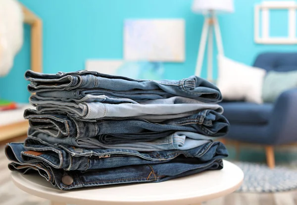 Pilha Jeans Elegantes Mesa Contra Fundo Desfocado — Fotografia de Stock