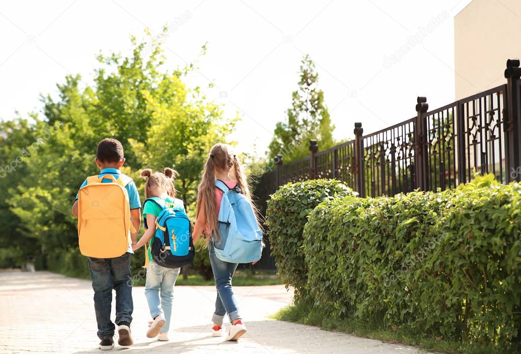 Cute little children with backpacks going to school