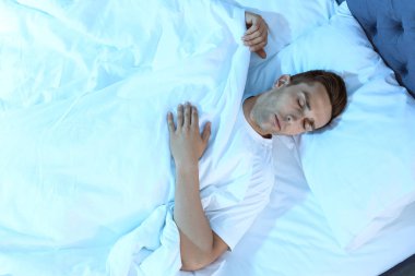 Gece, en iyi manzaraya yatakta uyuyan genç adam