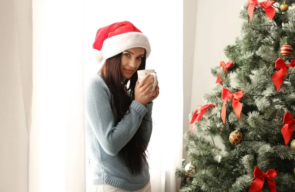 Noel Baba Şapkası Ile Noel Ağacı Evde Yakınındaki Içecek Fincan — Stok fotoğraf