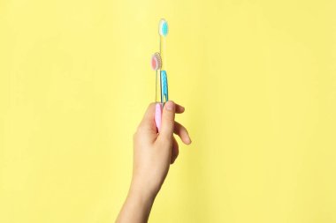Renkli arka planı el ile diş fırçası tutan kadın