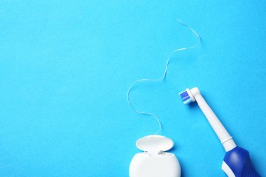 Elektrikli diş fırçası ve diş ipi renk arka plan üzerinde düz yatıyordu kompozisyonu
