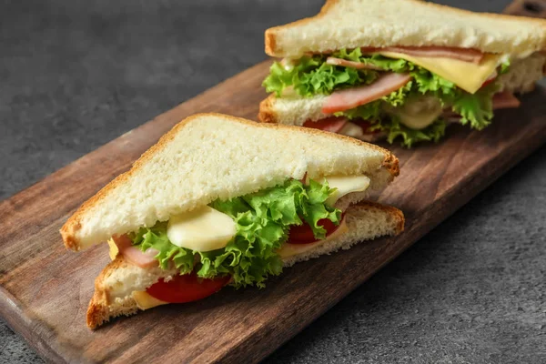Tasty toast sandwiches on wooden board. Wheat bread