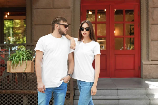 Young couple wearing white t-shirts on street